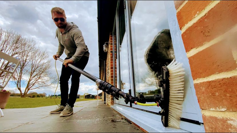 Cleaning ground-floor windows with a water-fed brush