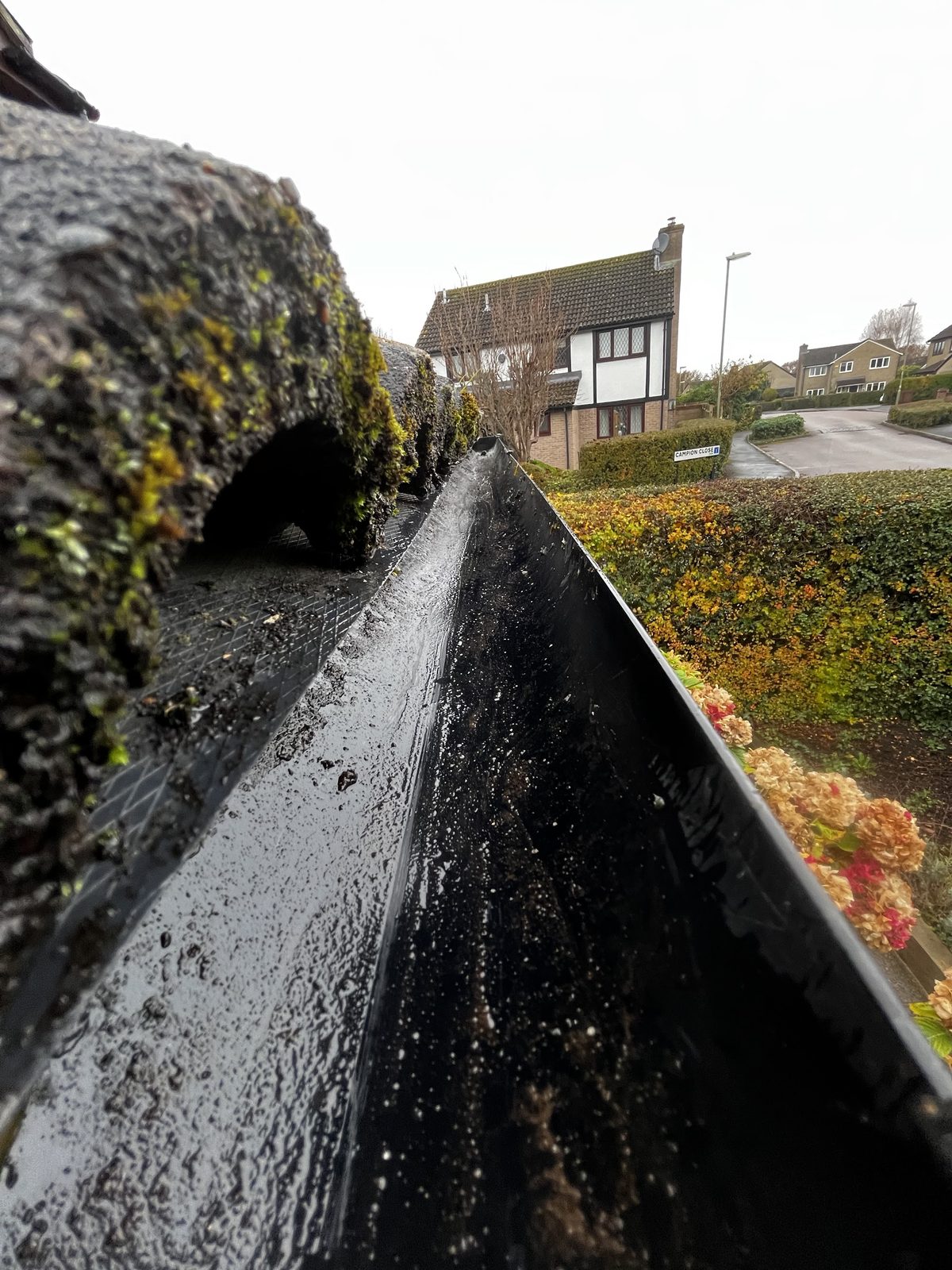A cleared gutter running along the roof edge of a house